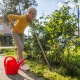 Frau mit Rückenschmerzen bei der Gartenarbeit.